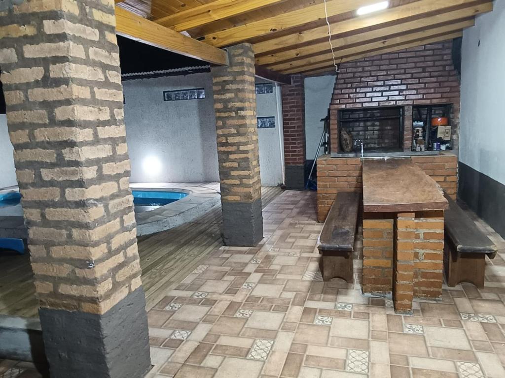 un patio con mesa y bancos en un edificio en AlojamientolaFamilia, en Puerto Iguazú