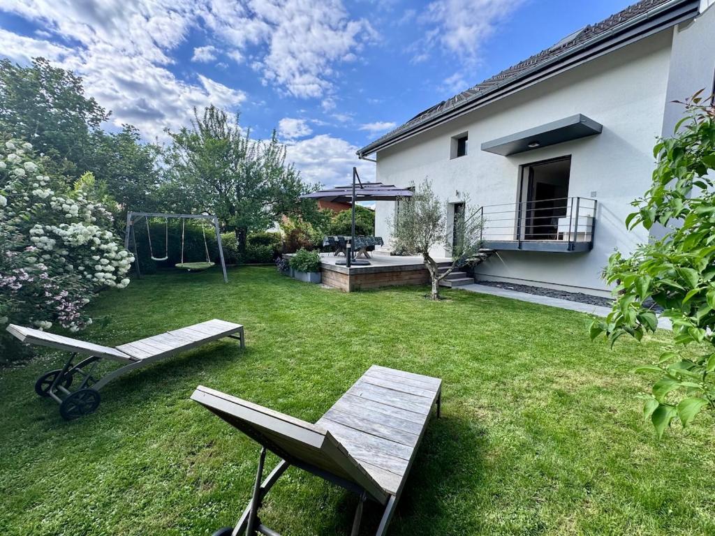 a backyard with a bench and a swing at Maison au calme et en ville in Meythet