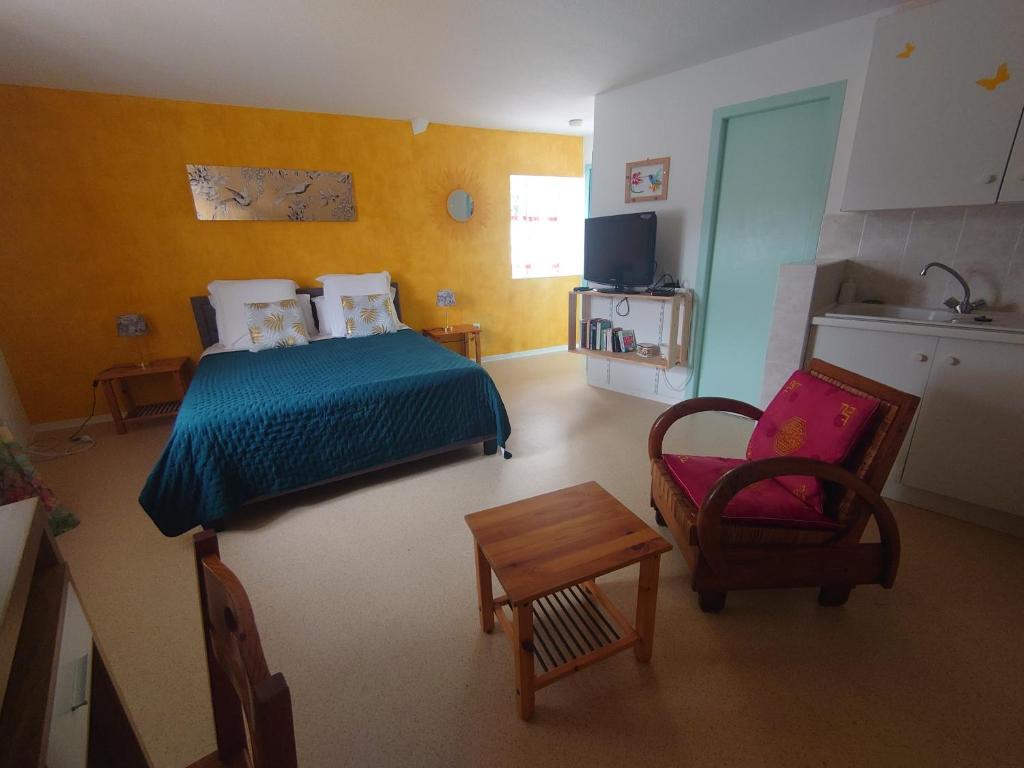 a small bedroom with a bed and a chair at La Buissière -Gîte aux Oiseaux in Duravel