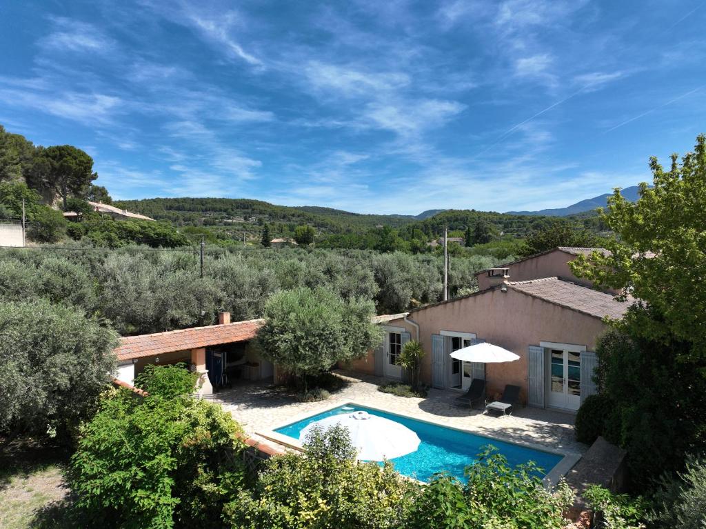 une maison avec une piscine dans une cour dans l'établissement The Olive Garden - Charming Villa for 10 with pool and fast Wifi, à Caromb