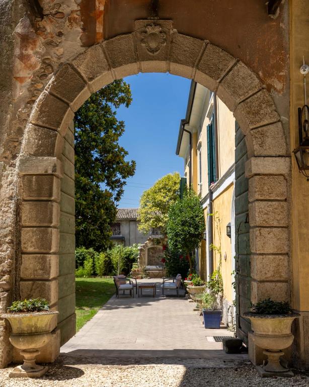 an archway leading into a garden with a picnic table at Corte Pozzol in Rivoli Veronese