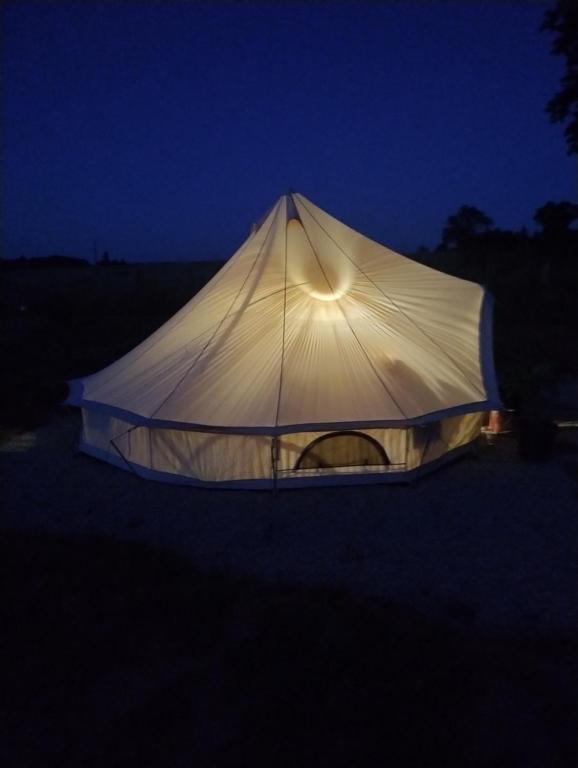 a tent that is lit up at night at Lodge romantique "le grand chêne" avec Jacuzzi privatif in Lapalisse