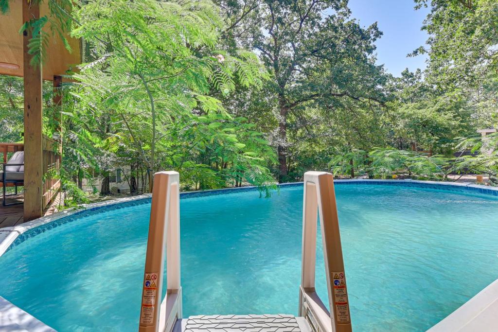 a swimming pool with blue water and trees at 3 Mi to Lake Texoma Gordonville Getaway! in Shay