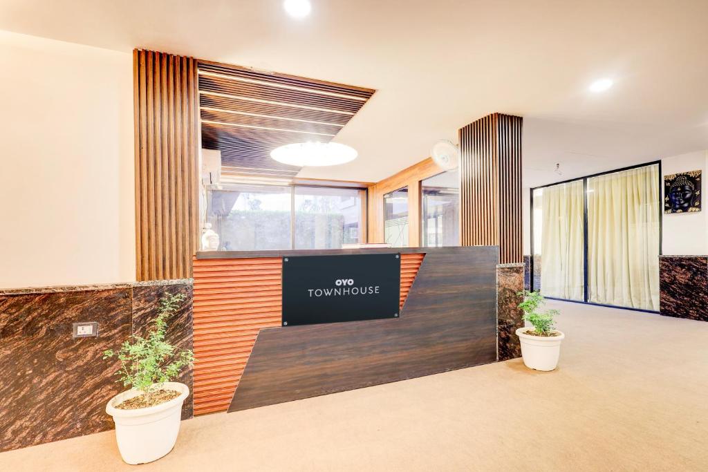 an office lobby with a reception desk and plants at Townhouse The Grand Villa in New Delhi