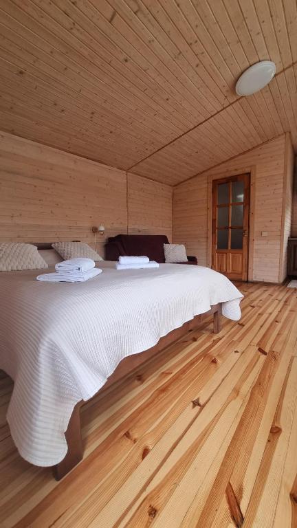 a bedroom with a large bed in a wooden room at Lake&Lodge in Rakovets