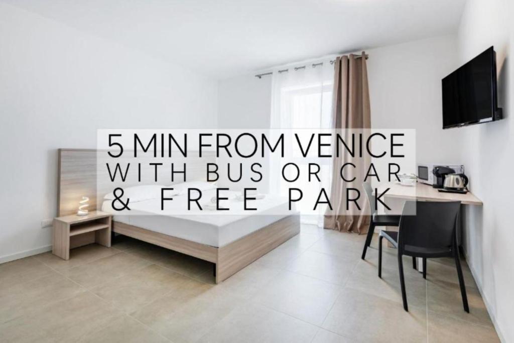 ein Wohnzimmer mit einem Schreibtisch und einem Tisch mit einem Computer in der Unterkunft Appia Rooms Free Parking e Fast Access to Venice by Bus in Venedig