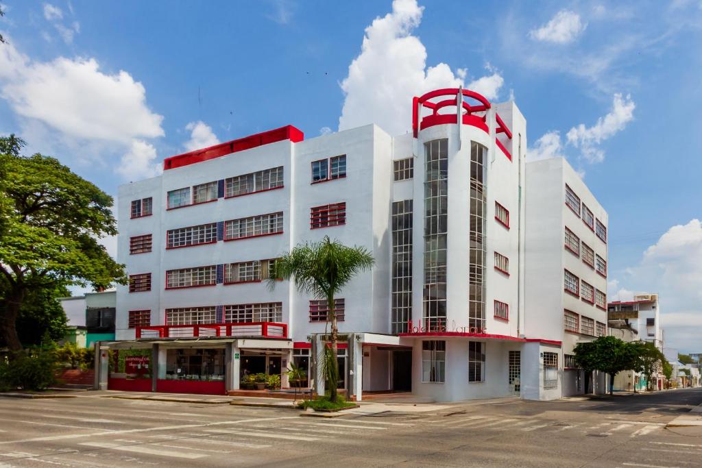 a large white building with a red roof at OYO Hotel Del Parque in Guadalajara