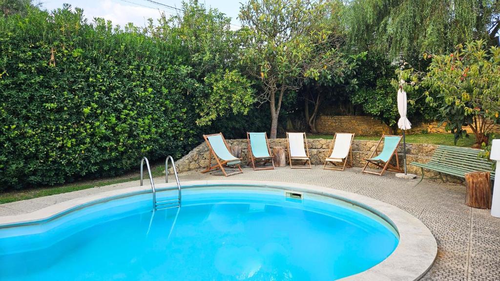 una piscina con tumbonas y un banco en Pool Sea & Country side Villa, en Aldeia de São Pedro