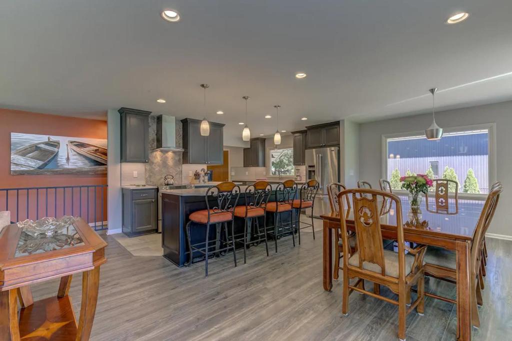 a kitchen and living room with a table and chairs at Welk Manor Private Waterfront Retreat on the Spokane River in Post Falls