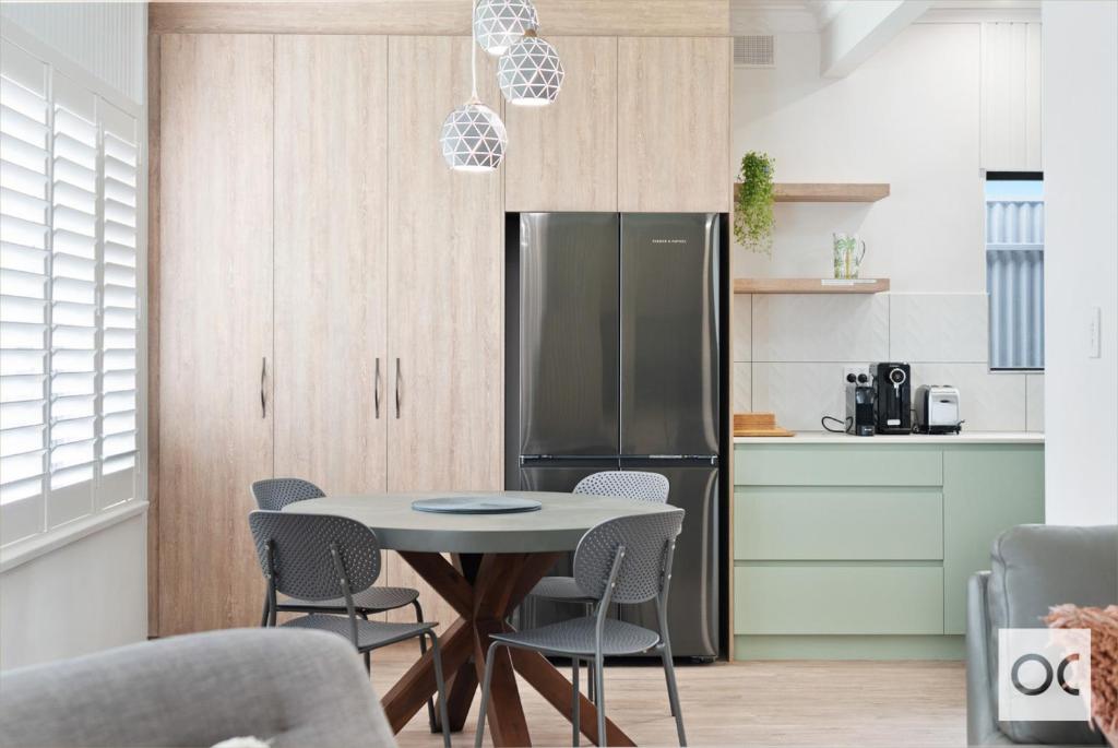 a kitchen with a table and chairs and a refrigerator at Granite Grove in Port Elliot