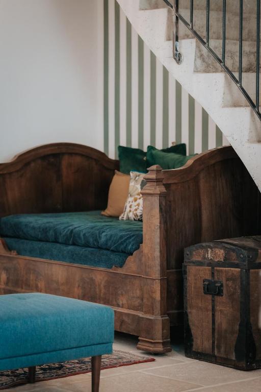 un canapé assis sous un escalier avec un canapé vert dans l'établissement La Vieille Ferme de Tassigny, à Meursault