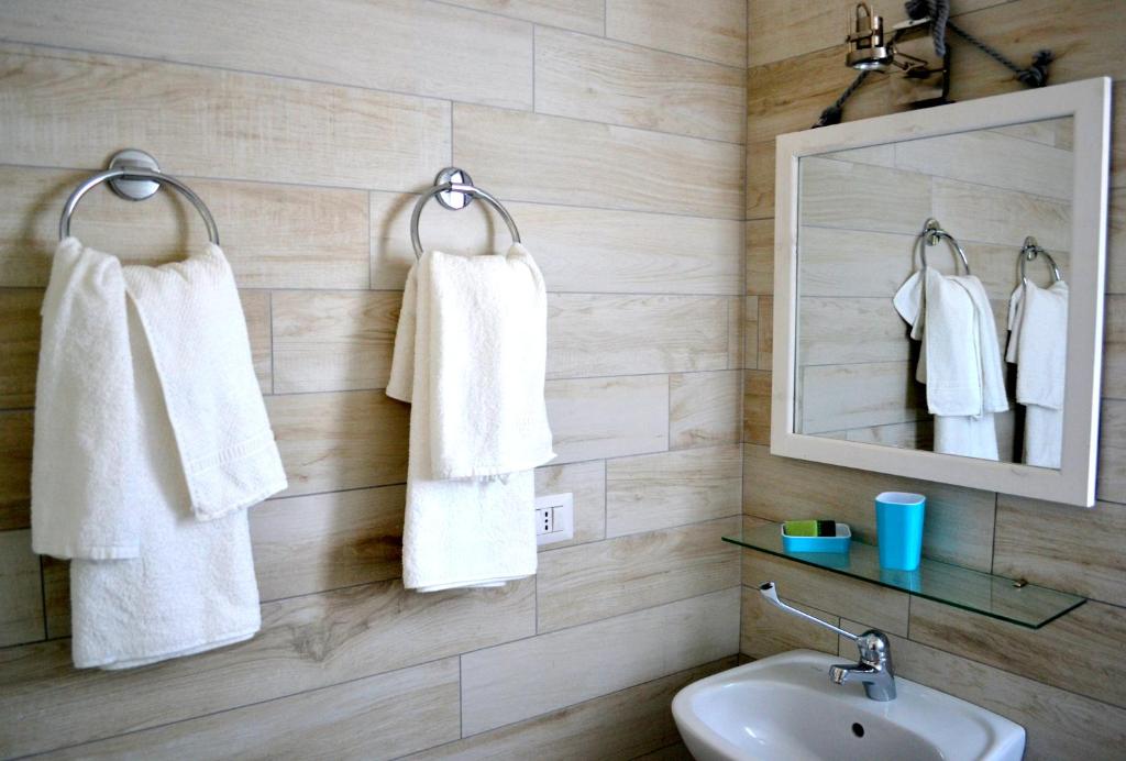 een badkamer met witte handdoeken aan de muur bij B&B La Casa Bianca di Porto Conte in Porto Conte