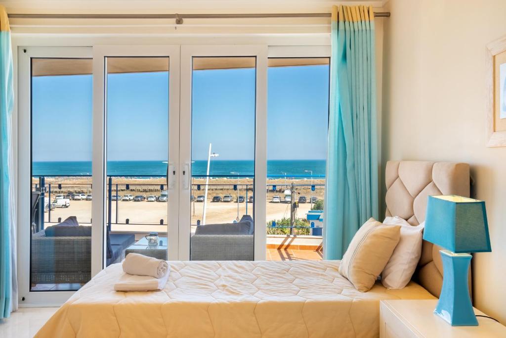 Un dormitorio con una cama y vista al mar. en Casa Areia Ornata, en Lagos