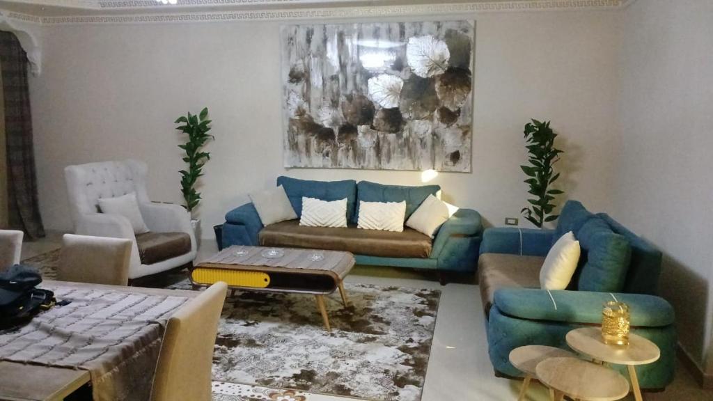 a living room with a blue couch and chairs at Fully Brand New Furnished Apartment in Sheikh Zayed