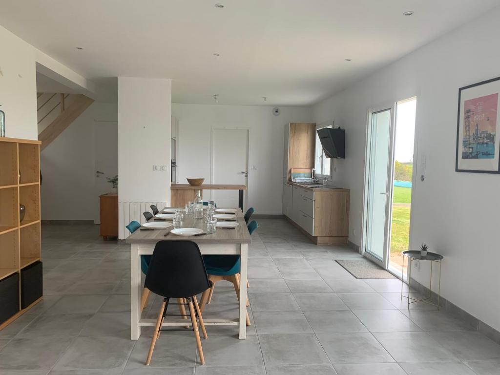 une cuisine et une salle à manger avec une table et des chaises dans l'établissement Maison neuve, à Plouguerneau