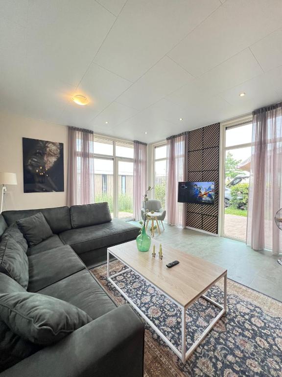 a living room with a couch and a coffee table at Lakeside Retreat at Veluwe in Nunspeet
