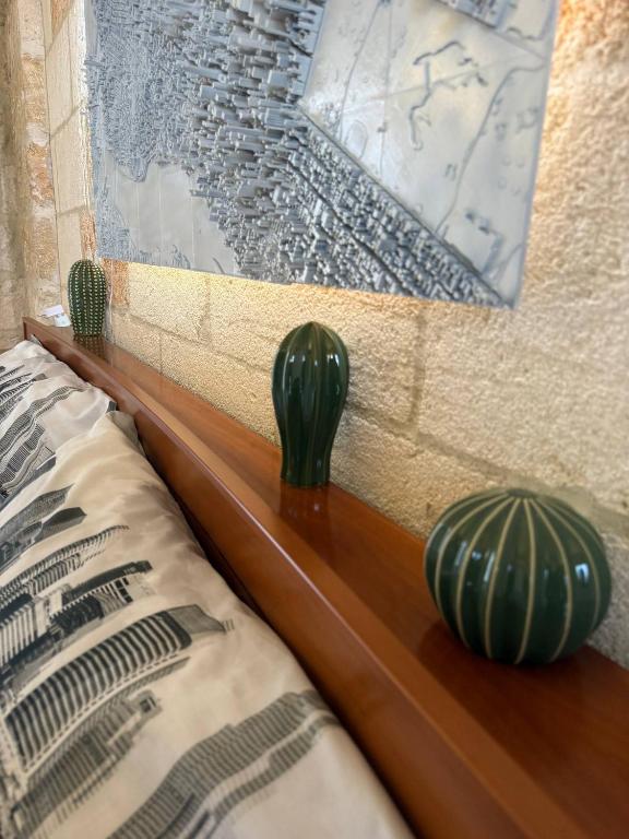 two green vases sitting on a wooden head board at Largo Spani 15 in Veglie