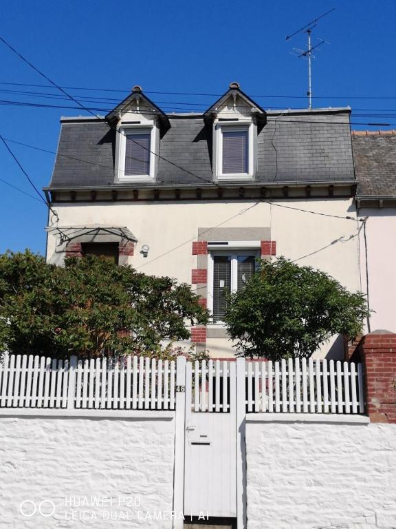 a white fence in front of a white house at chambres dans Maison individuelle 46 Rue de Luzel in Saint-Brieuc