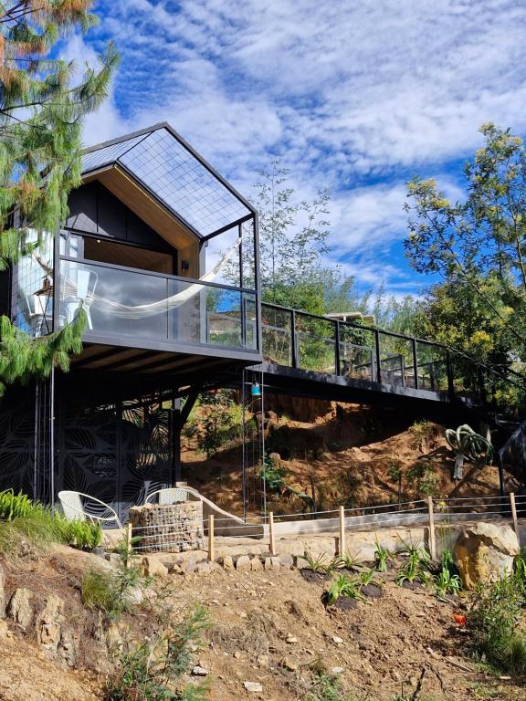 NemocónにあるVive Rela Tiny Housesの橋のある丘の上の家