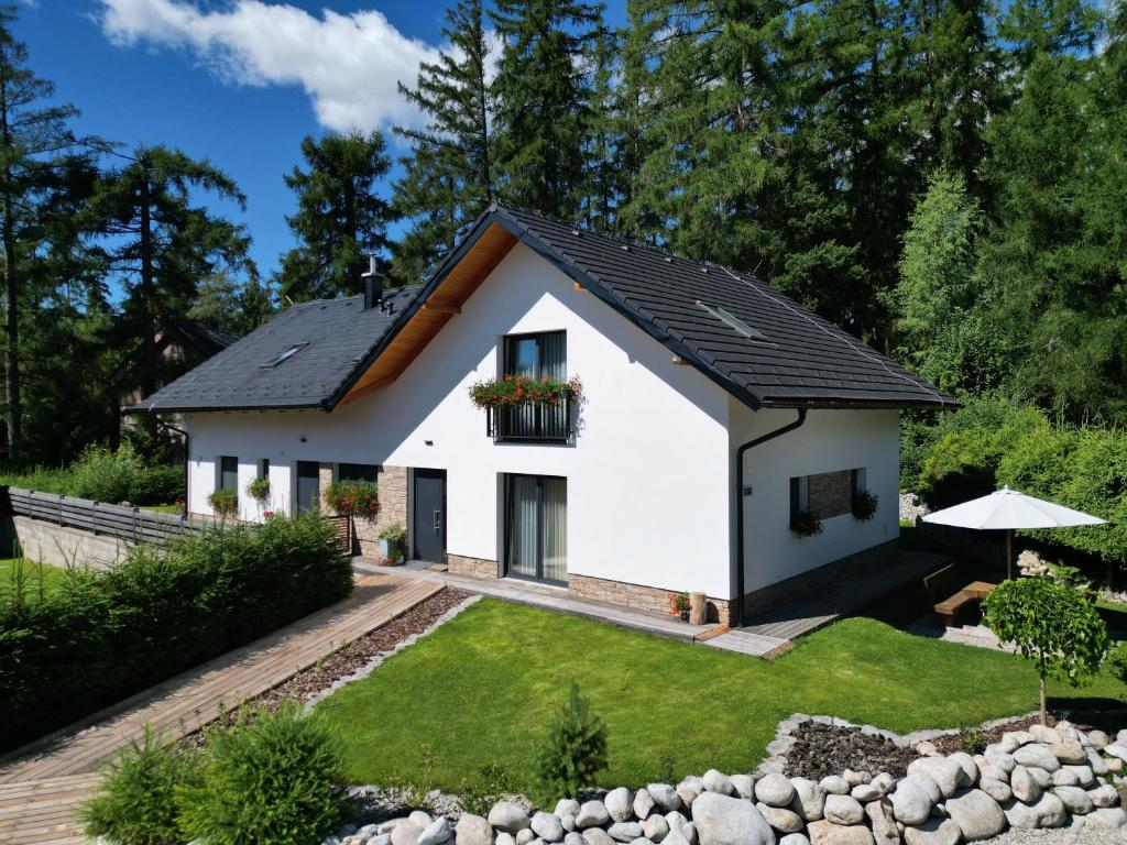 a white house with a black roof at Apartmány Runi in Stará Lesná