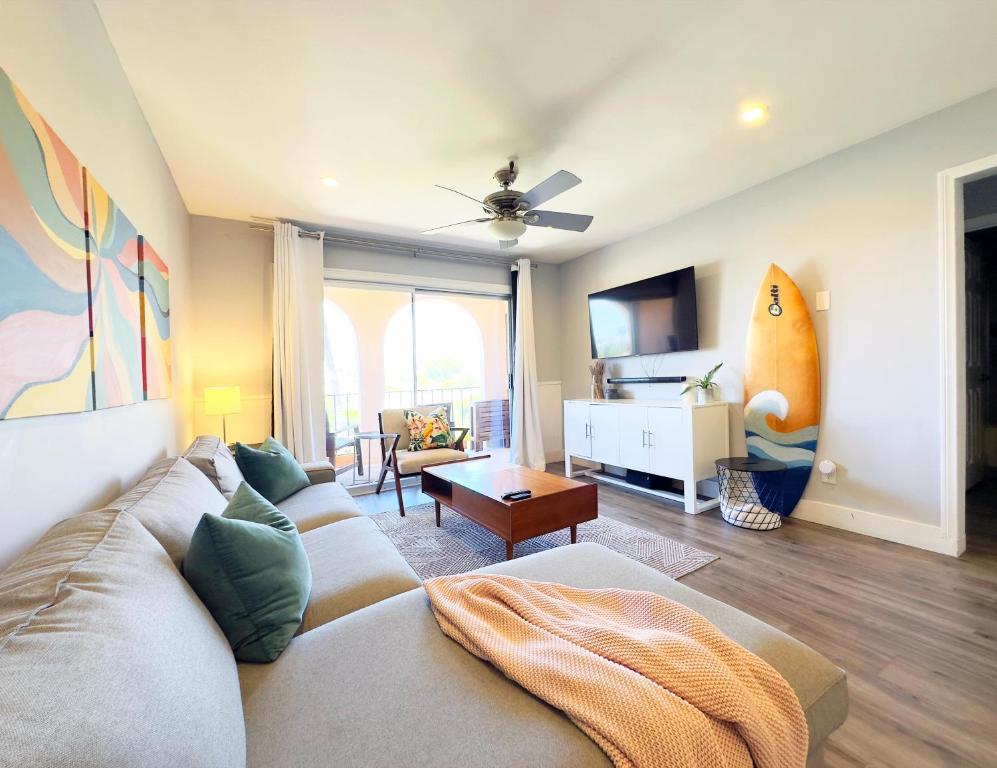 a living room with a couch and a surfboard on the wall at 2 bed 2 bath penthouse condo with AC and Ocean Views in San Diego