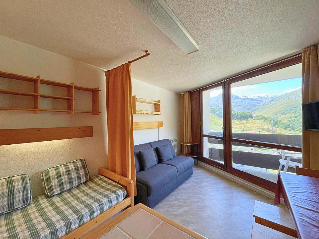 a living room with a couch and a large window at Studio pour 3 avec balcon sud, au pied des pistes, Les Belleville - FR-1-452-191 in Les Menuires