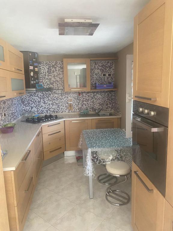 a kitchen with a table and a sink and a stove at Casa vacanze Melania in Cupra Marittima