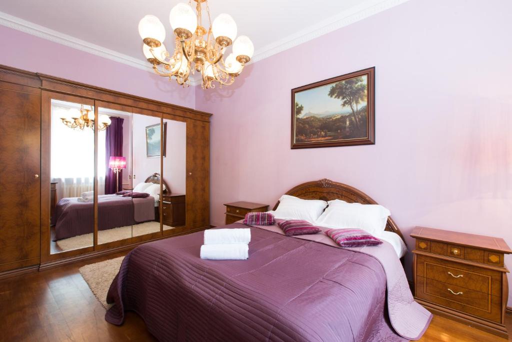 モスクワにあるApartment Presnenskayaのベッドルーム(紫色のベッド1台、鏡付)