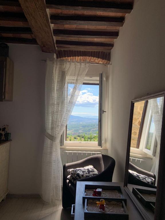 a room with a chair and a window with a view at Casa Giovy in Roccastrada