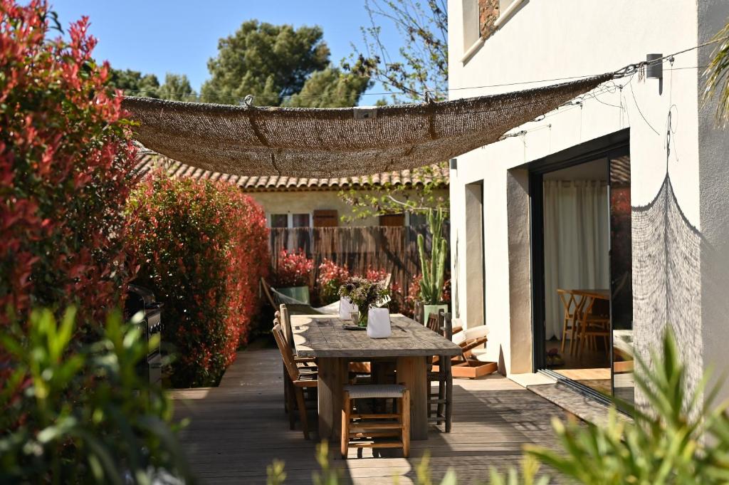 un tavolo e sedie di legno su un patio di Modern and bright vacation home a Bormes-les-Mimosas