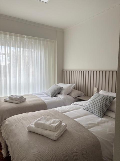 two beds with towels on them in a bedroom at Cardenal Centro in Monforte de Lemos