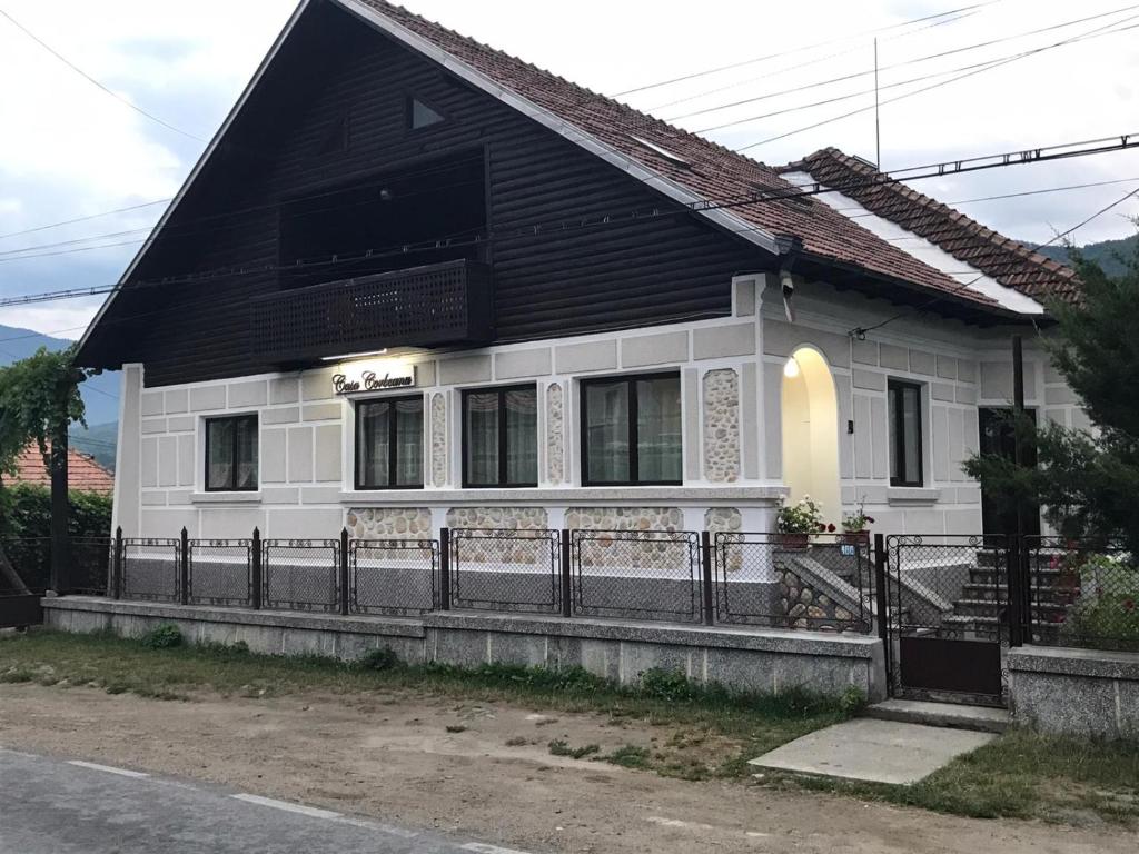 a white and black house with a black roof at Casa Corbeanu Transfagarasan in Bucşeneşti