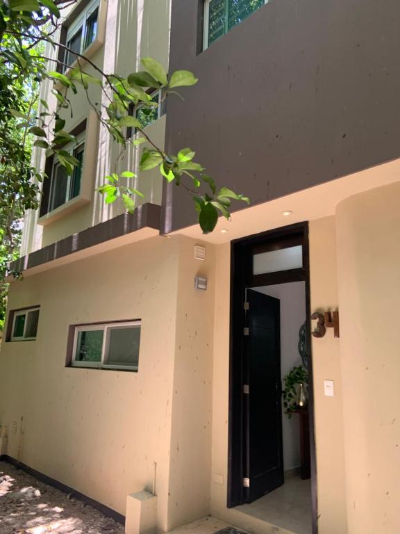 un edificio con una puerta negra a un lado. en La Escondida 34, en Playa del Carmen