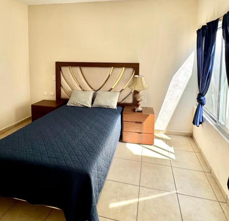 a bedroom with a bed with a blue comforter at JUCAR Place in Villa Hidalgo