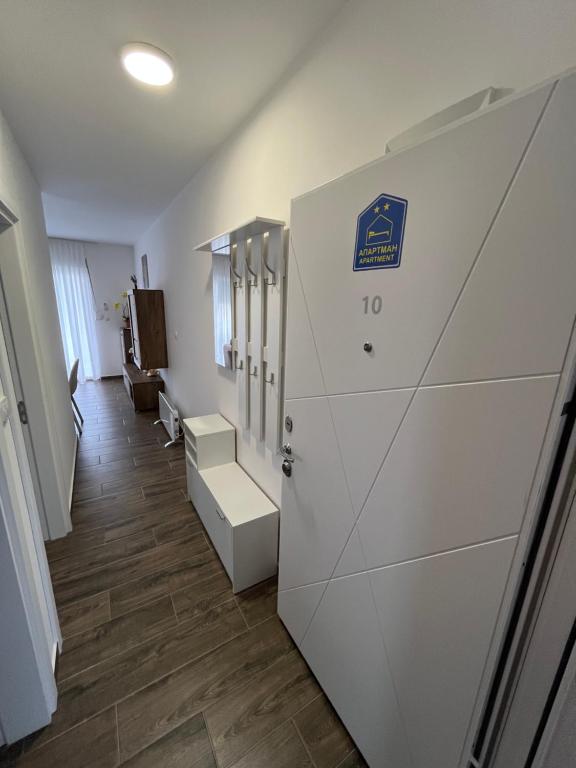 a locker room with a white door and a hallway at Mića Apartment in Veliko Gradište