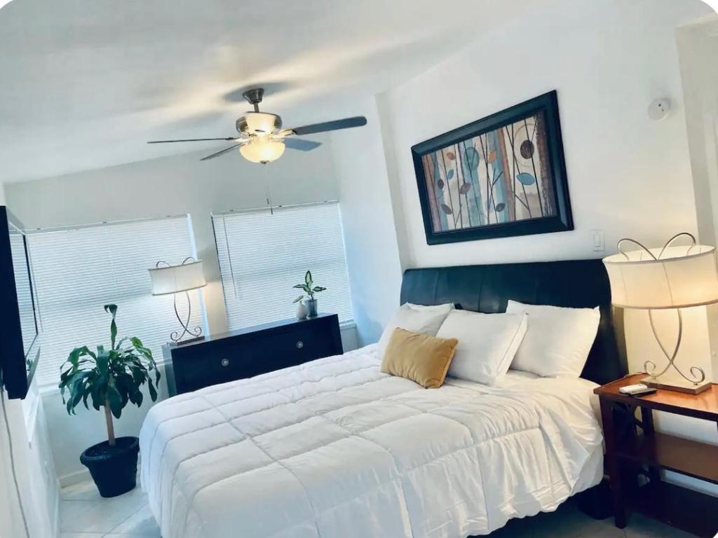 ポンパノビーチにあるFlorida Charmのベッドルーム(白いベッド1台、天井ファン付)