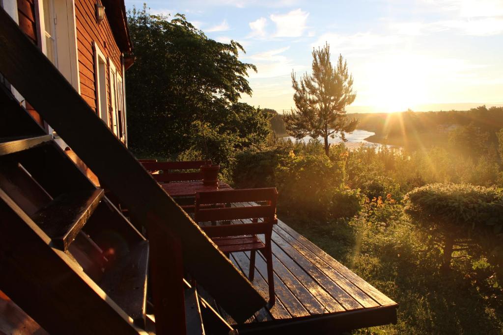 a bench sitting on top of a porch with the sunset at Lillstugan in Älvkarleby