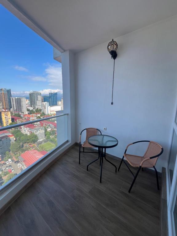 a room with two chairs and a table and a window at Batumi Sea Apartment in Batumi