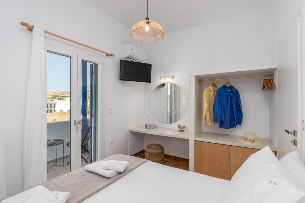 a bedroom with a bed and a mirror and a sink at Aphrodite's Child Milos Maisonette in Adamantas