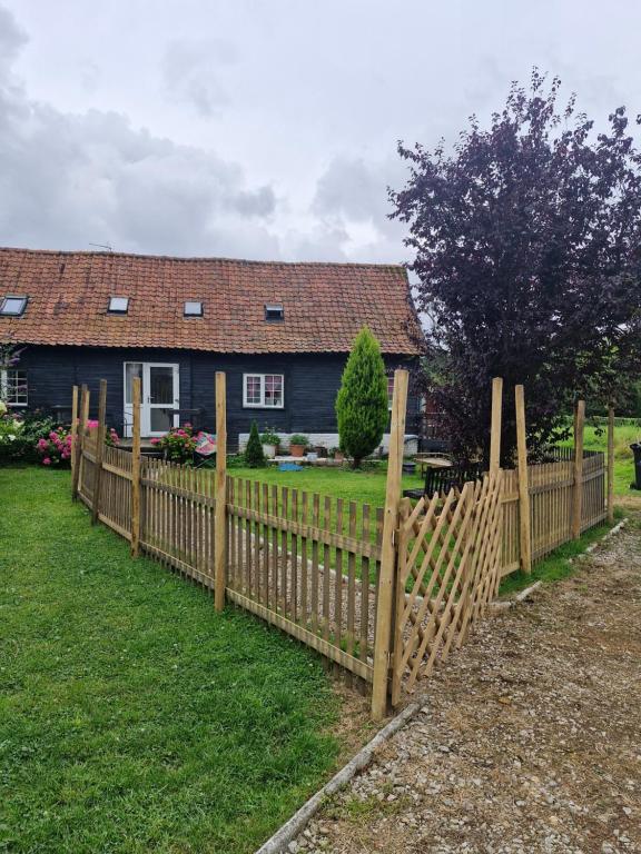 a wooden fence in front of a house at Cosy cottage at rustic escapes 