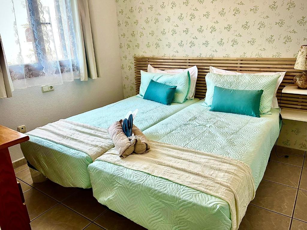 two beds in a bedroom with blue and white at La Casita Bonita del Faro Holiday Retreat in Gran Alacant in Gran Alacant