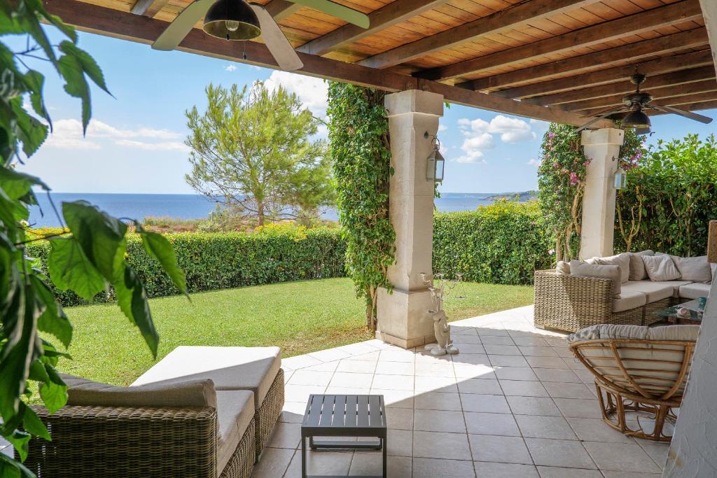 een terras met pergola en stoelen en de oceaan bij Villa 19 in Santa Cesarea Terme