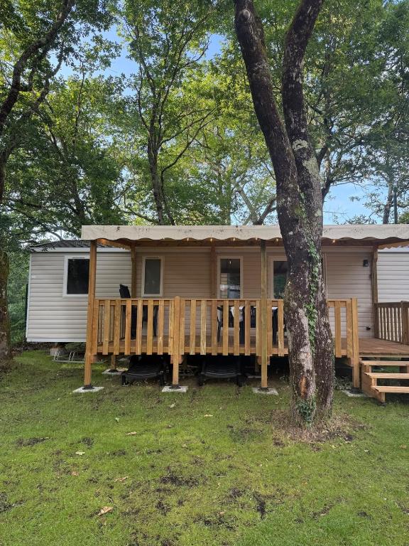 a mobile home with a porch and a tree at Mobil home B1Bis La Pointe LB in Capbreton