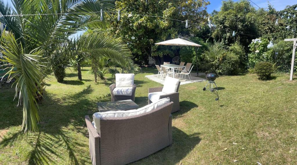 - une cour avec 2 chaises et une table avec un parasol dans l'établissement Jolie maison, idéalement située, à Crozon