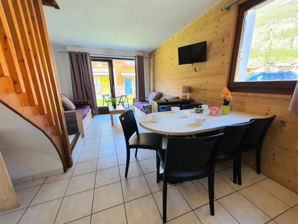 une salle à manger avec une table et des chaises dans l'établissement Chalets Jardin Alpin - Chalet mitoyen lumineux · Accès pistes par navette · Wifi gratuit MAE-5014, à La Salle Les Alpes