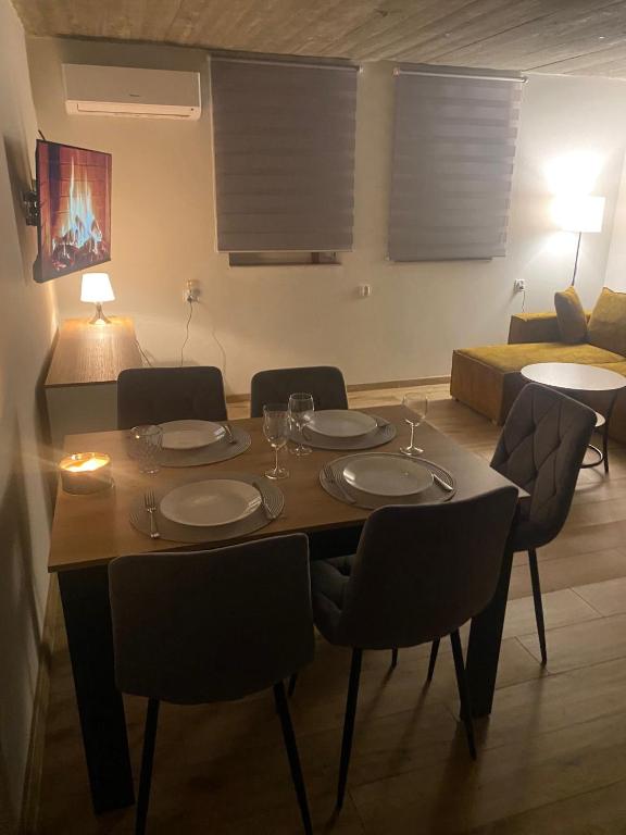 a dining room table with chairs and a couch at Domki pod Wolinem in Wolin