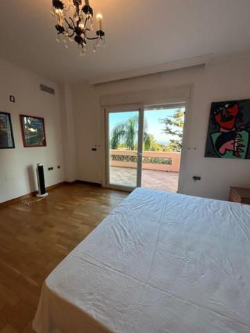 ein Schlafzimmer mit einem großen Bett und einem großen Fenster in der Unterkunft Chalet pareado in Marbella