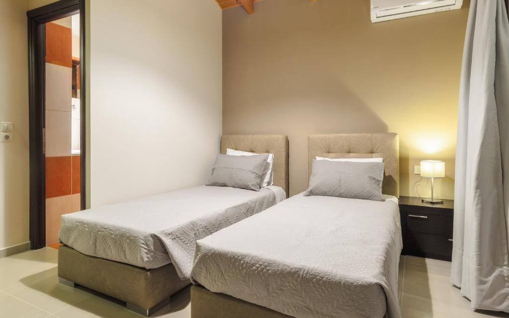two beds in a small room withermottermottermottermott at Eden Villas in Anafonítria