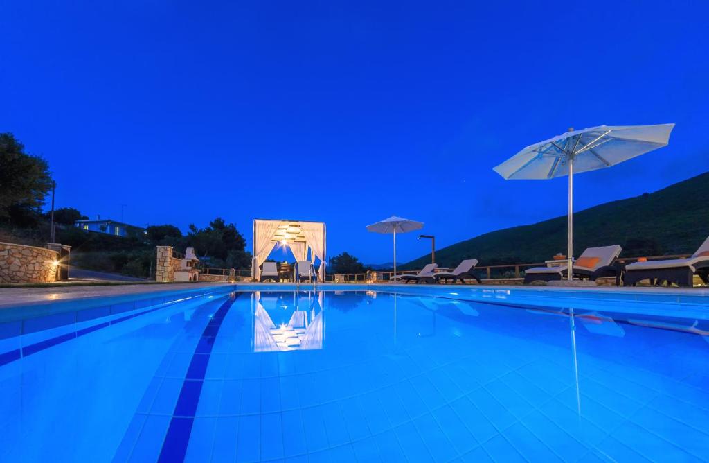 a swimming pool at night with a blue sky at Eden Villas in Anafonítria