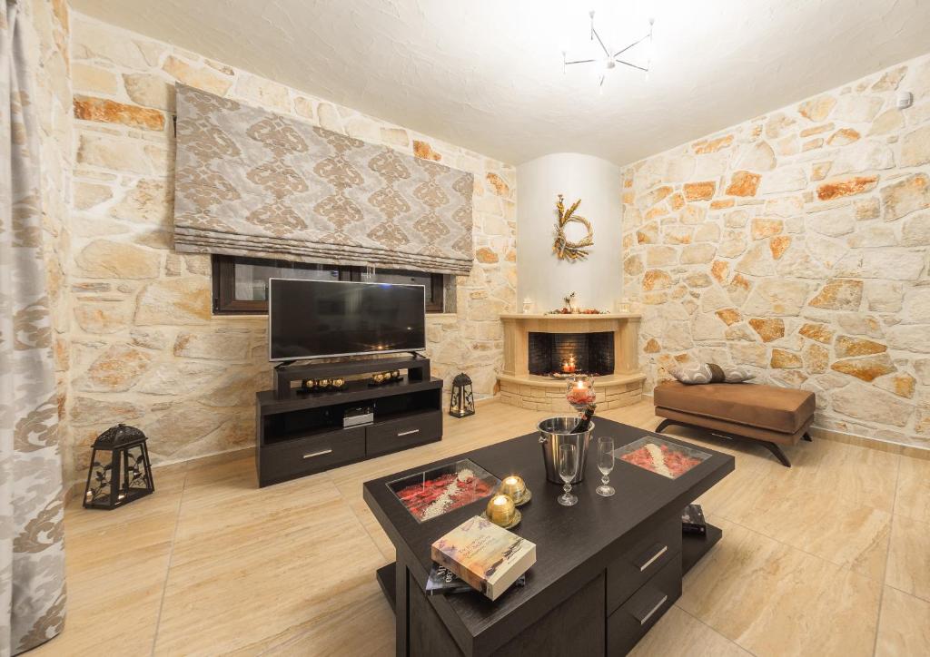 a large living room with a stone wall at Eden Villas in Anafonítria